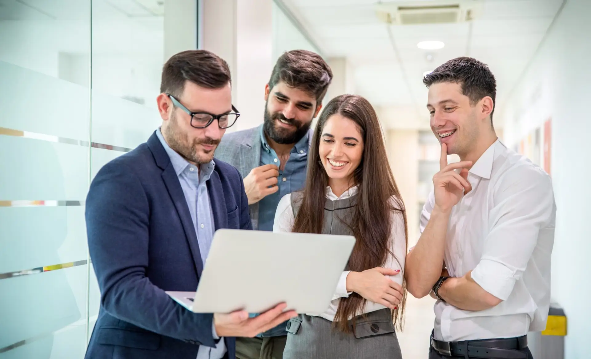 Cuatro profesionales mirando portátil en oficina