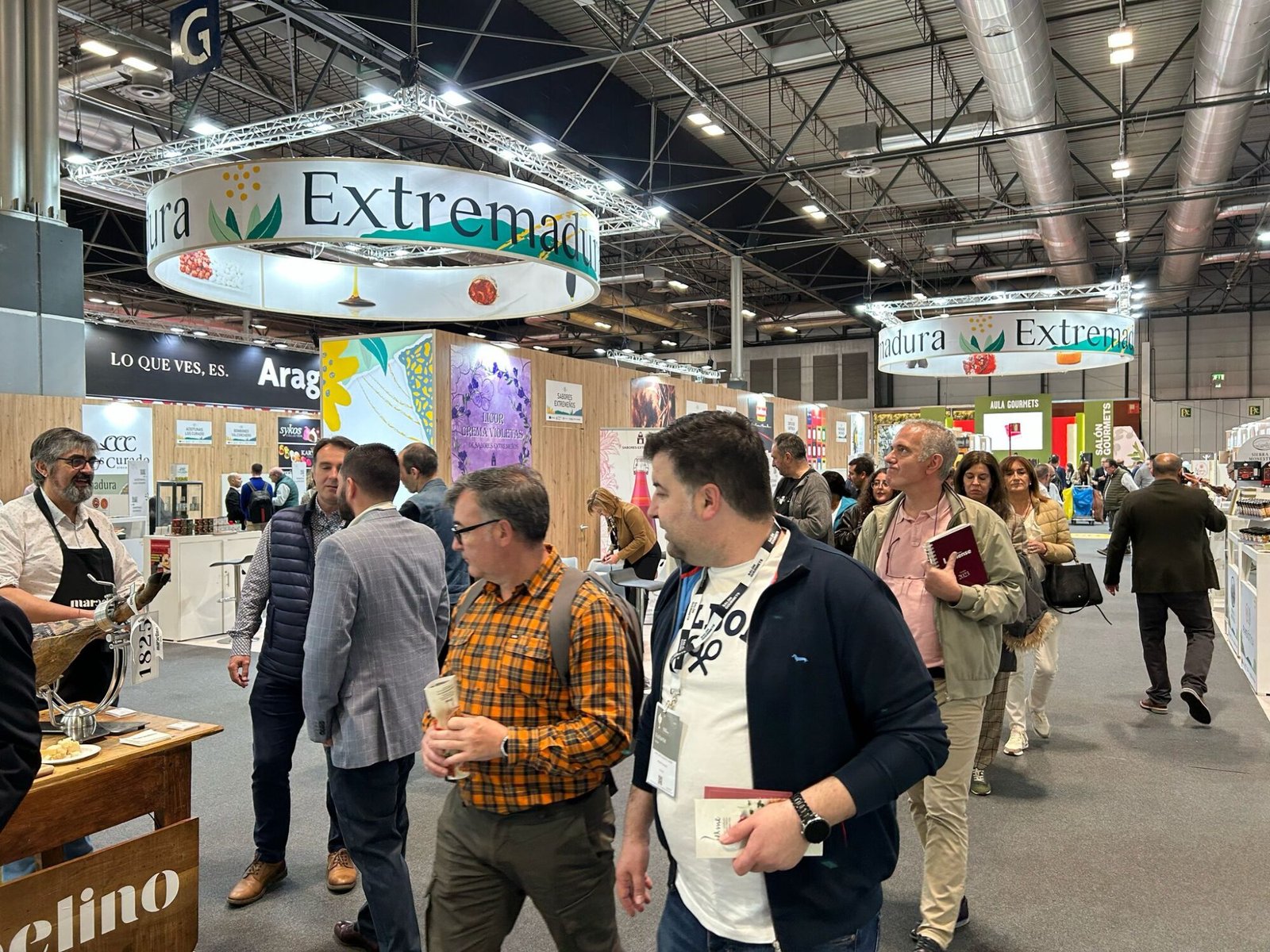 Feria con personas y estands de productos.