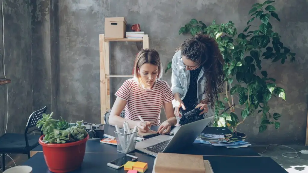 Dos mujeres trabajando con portátil y cámara